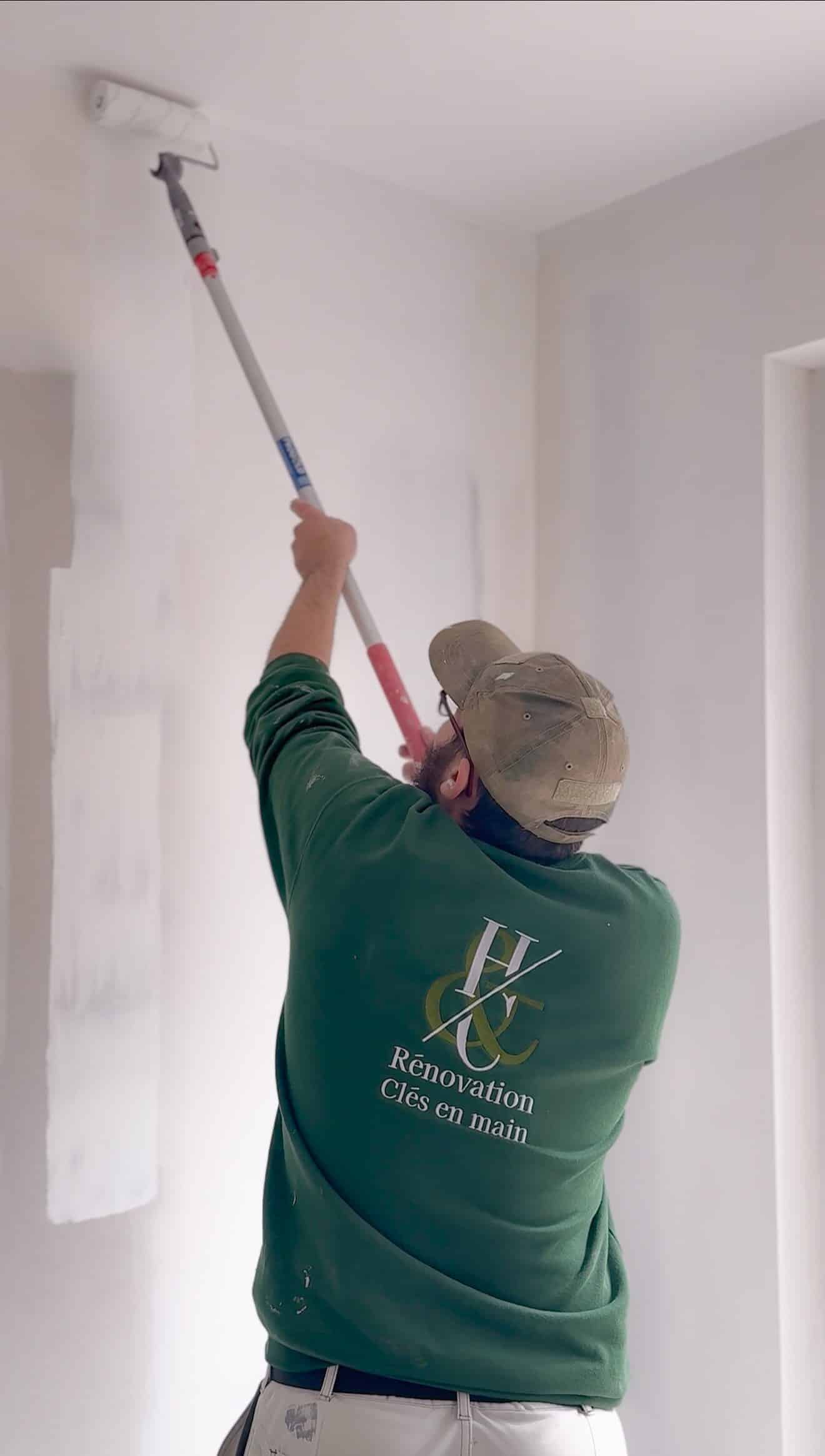 Artisan H&C Rénovation appliquant la peinture au rouleau sur un mur lors d'un chantier de rénovation intérieure à Montpellier.
